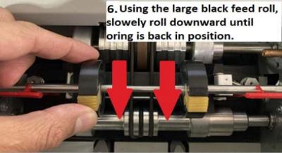 Using the large back feed roll, slowly roll downward until oring is back in position